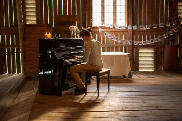 Pianist ved piano i låve
